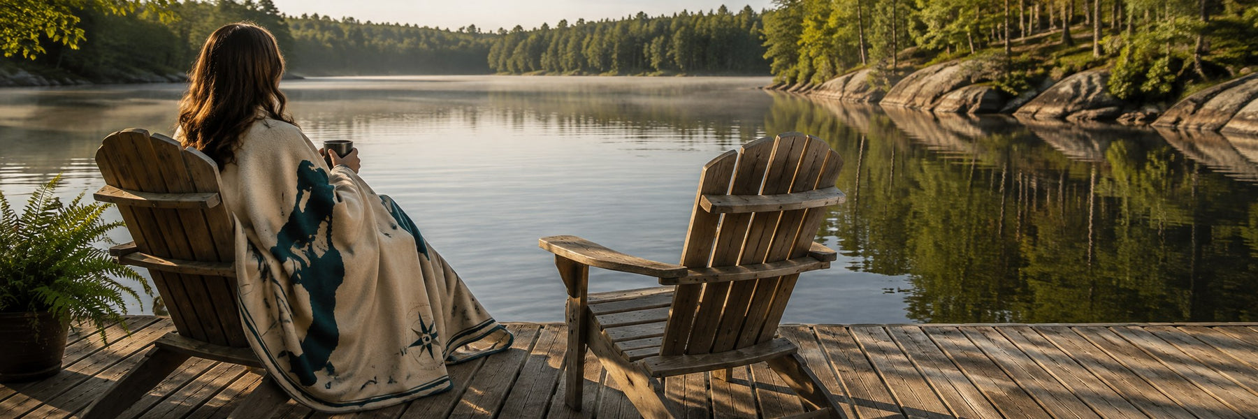 A LakeBlankets blanket wrapped around a person enjoying a quiet morning on the dock